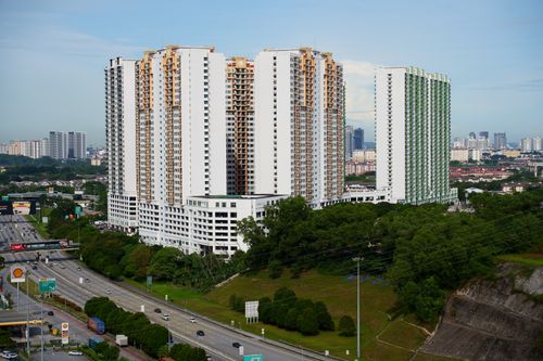 Free Aerial view of high-rise residential buildings alongside a highway in a bustling urban cityscape. Stock Photo