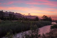 日落色彩缤纷，河流与山脉在自然摄影中展现出美丽的景观