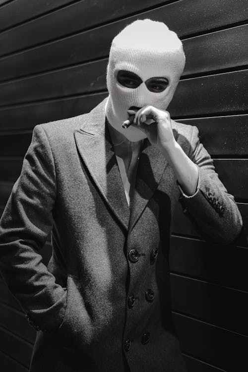 Person in Suit and Balaclava Smoking · Free Stock Photo
