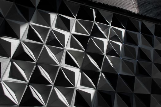 Modern black and white geometric architectural wall with triangular shapes.