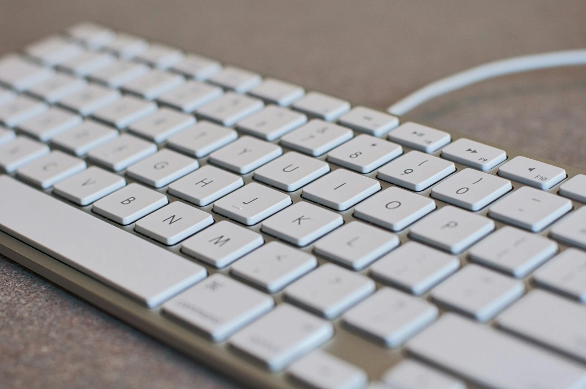 Detailed image of a white computer keyboard with focus on keys, ideal for tech content.