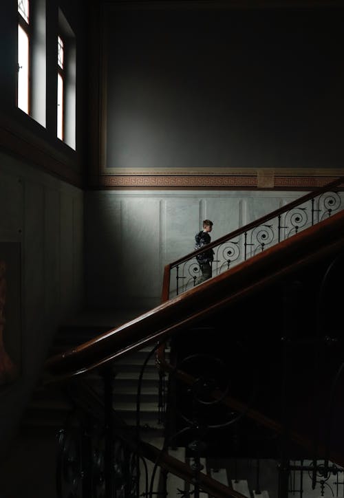 Man Walking up the Stairs in a Dark Interior 