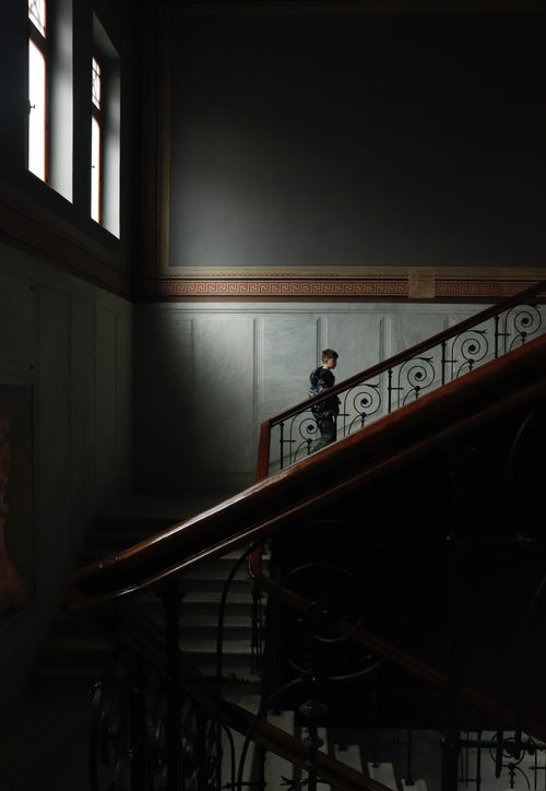 Free Moody interior of a classic building with a man on the staircase. Stock Photo