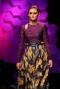 在充满活力的灯光下，优雅的模特于时装秀上展示着时尚的花卉图案连衣裙