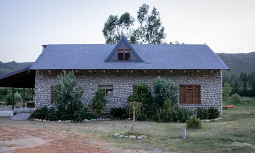 бесплатная Серый бетонный дом в окружении деревьев Стоковое фото
