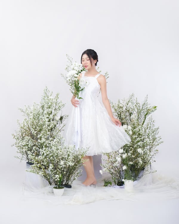 Young Woman in a White Dress Among Flowers