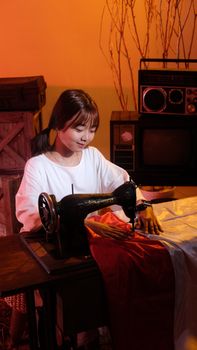 A woman using a vintage sewing machine in a retro-themed room, evoking a sense of nostalgia.