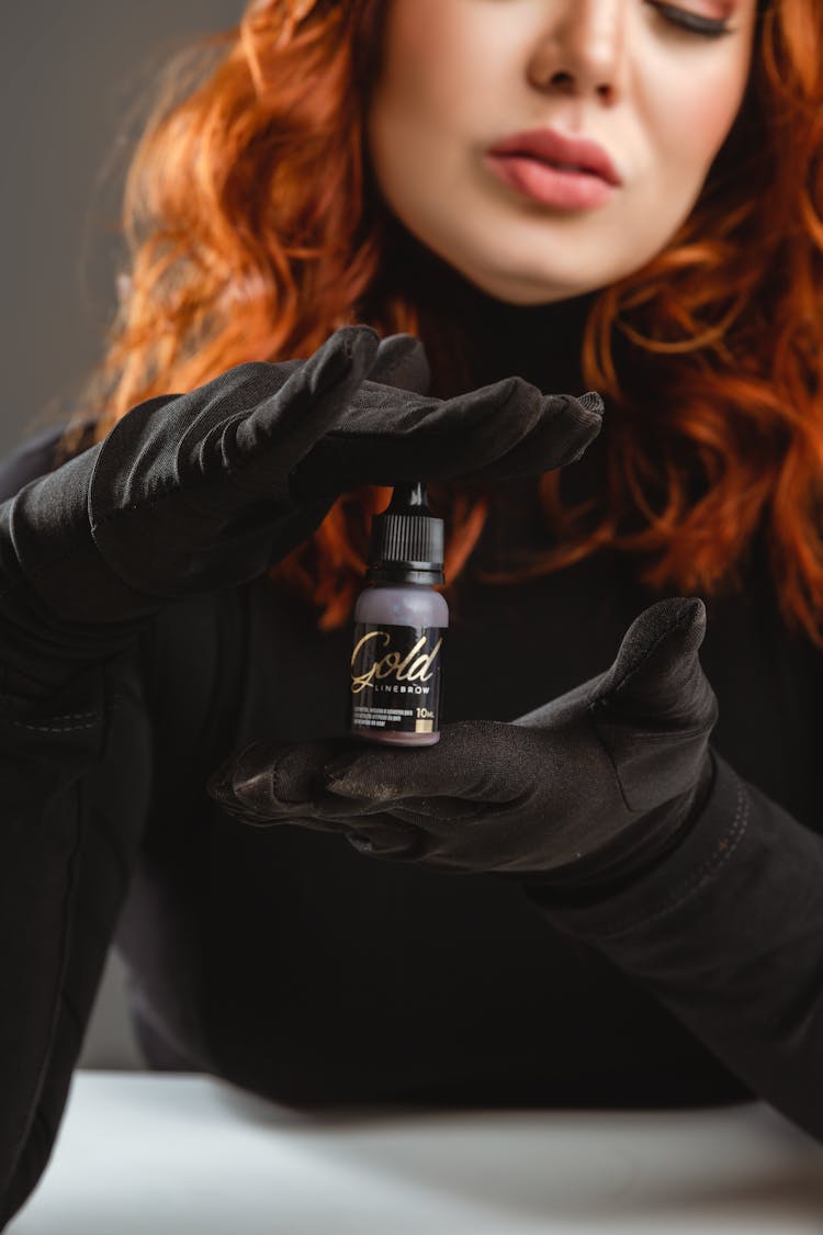 Model In Black Gloves Holding A Bottle Of Pigment For Permanent Makeup From Mag Color