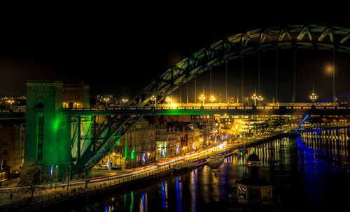Free Explore the vibrant city nightlife with this stunning view of an illuminated bridge and bustling downtown area. Stock Photo