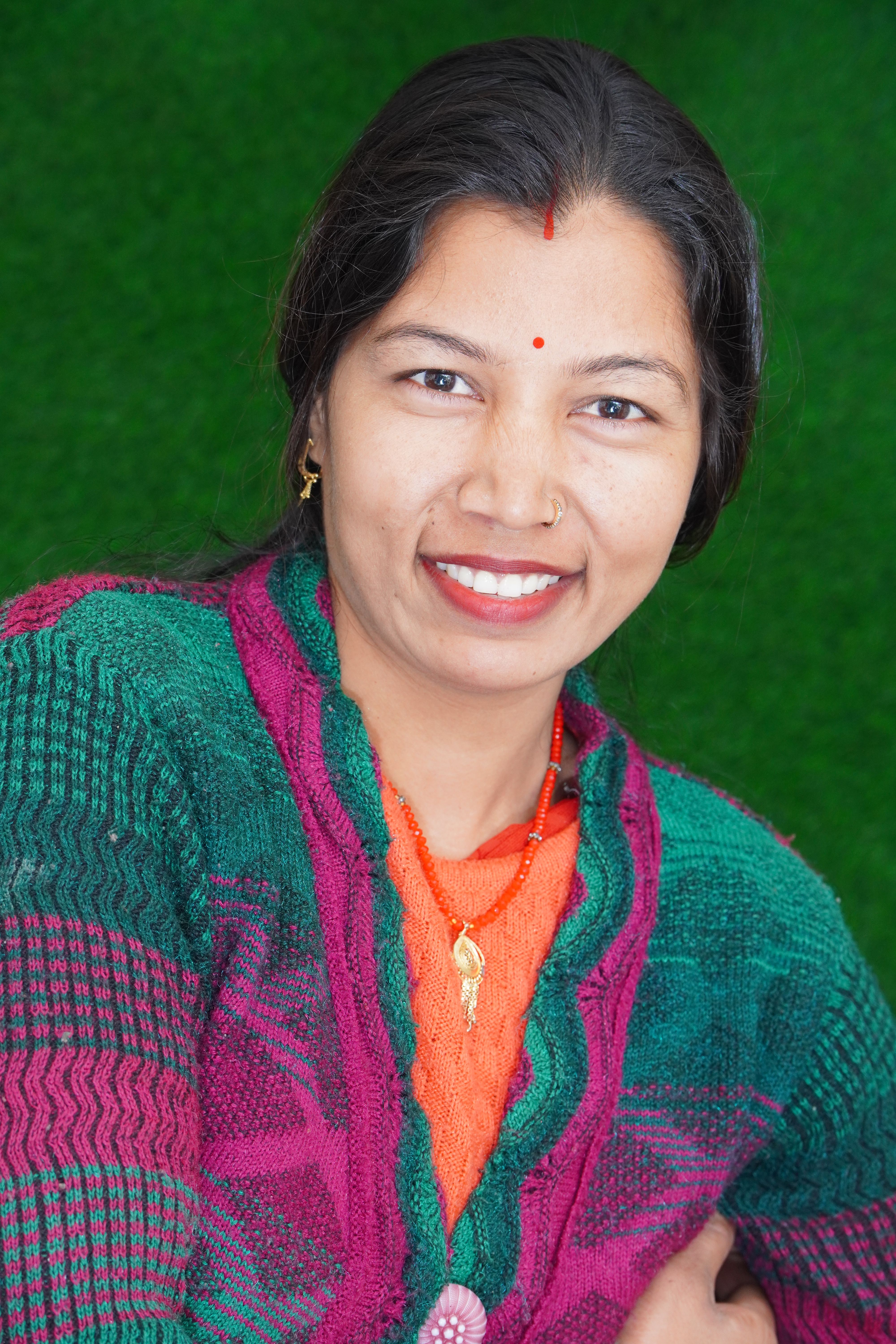Portrait of a smiling woman in a vibrant, traditional Indian sweater