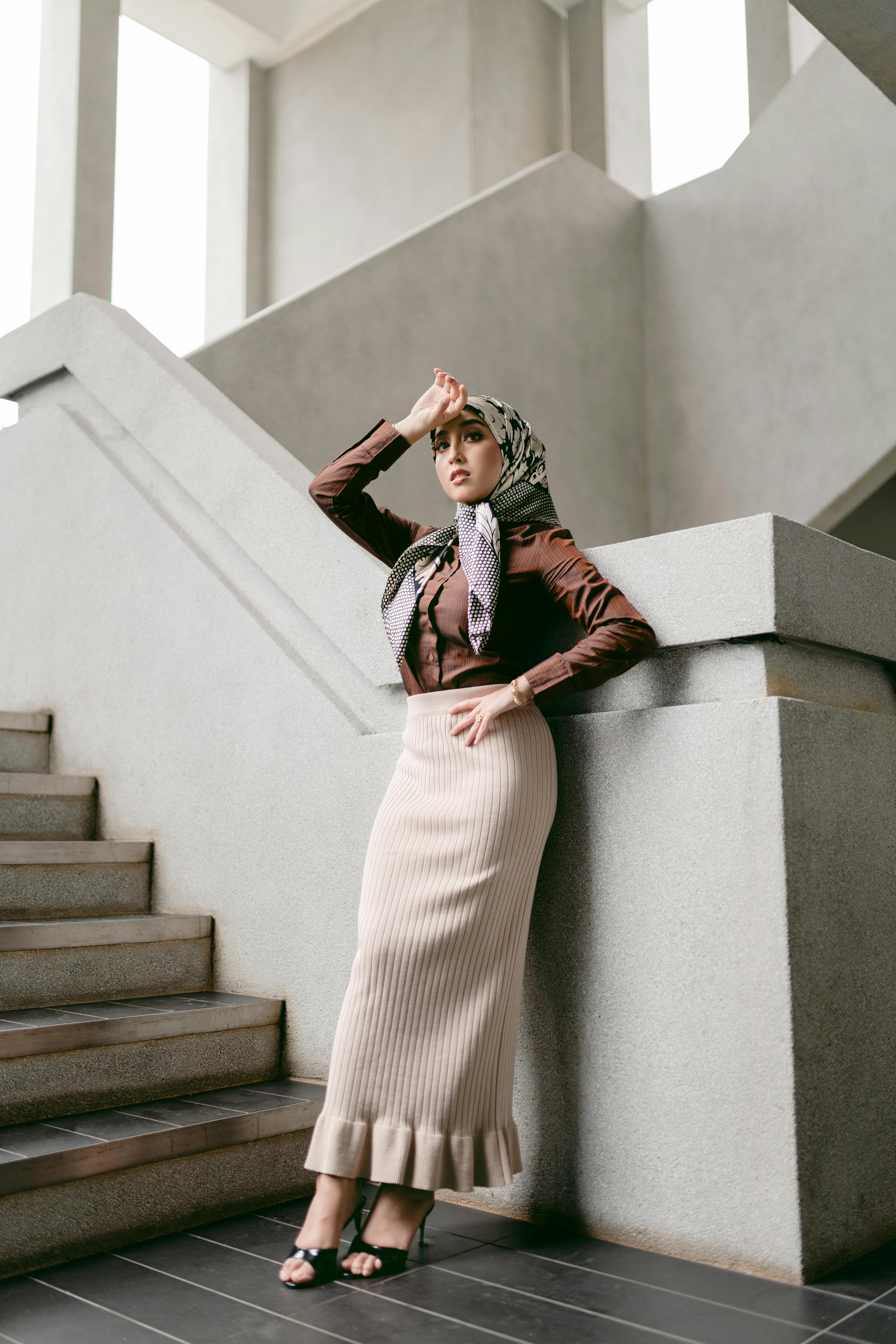 a woman in a skirt and heels standing on some stairs