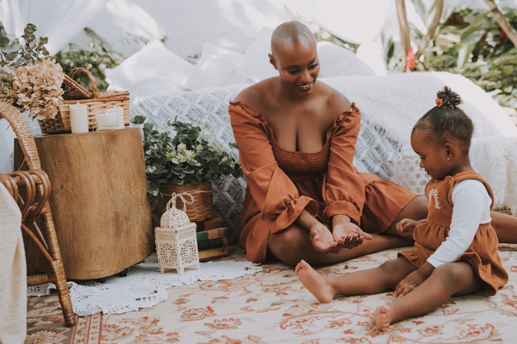 Mother And Daughter Playing On A Bedroom Rug