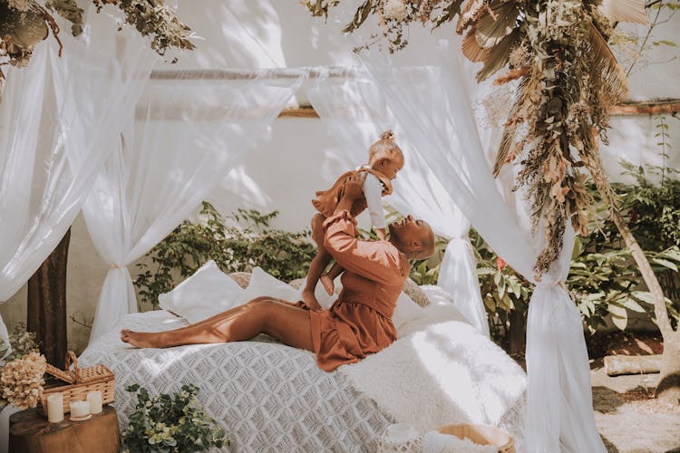 Mother And Daughter Playing On A Bed