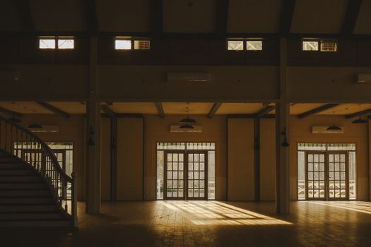 A spacious and elegant mansion interior with natural light streaming through large windows.