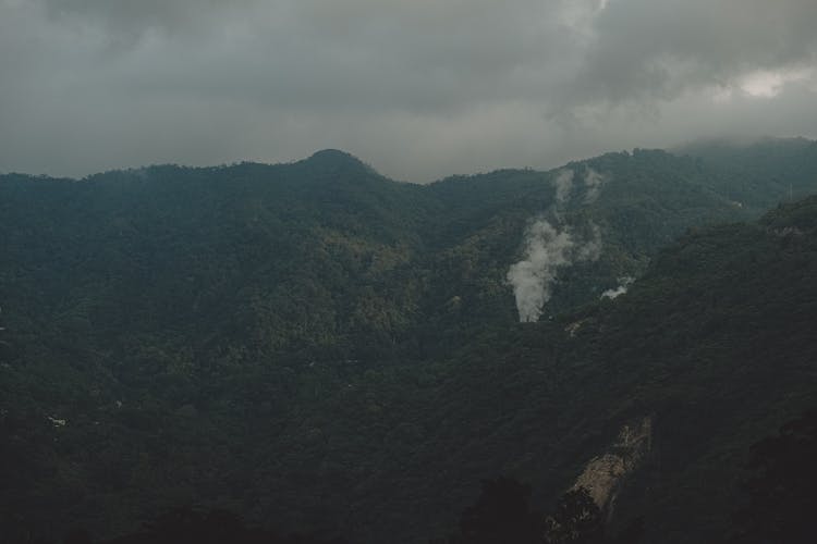 Smoke Rising Over Mountain Forest