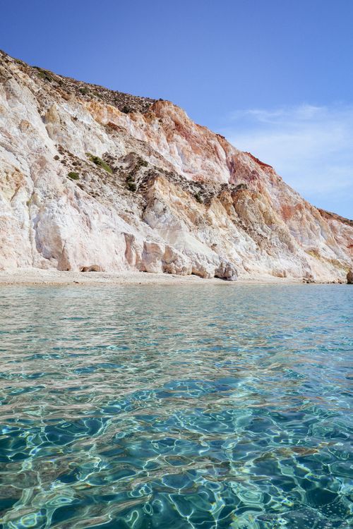 Free Discover stunning cliffs descending into crystal-clear turquoise waters on a sunny day. Stock Photo