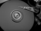 一张展示开放式硬盘机械组件的黑白特写照片