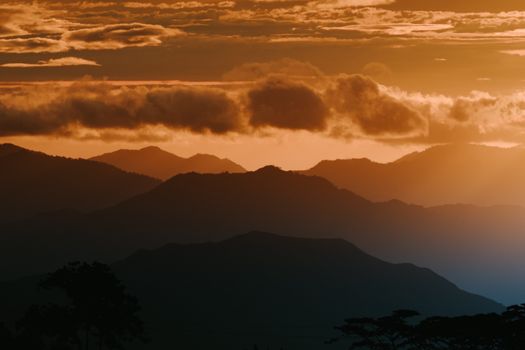 Silhouetted mountain range under a dramatic sunset sky with vivid colors.
