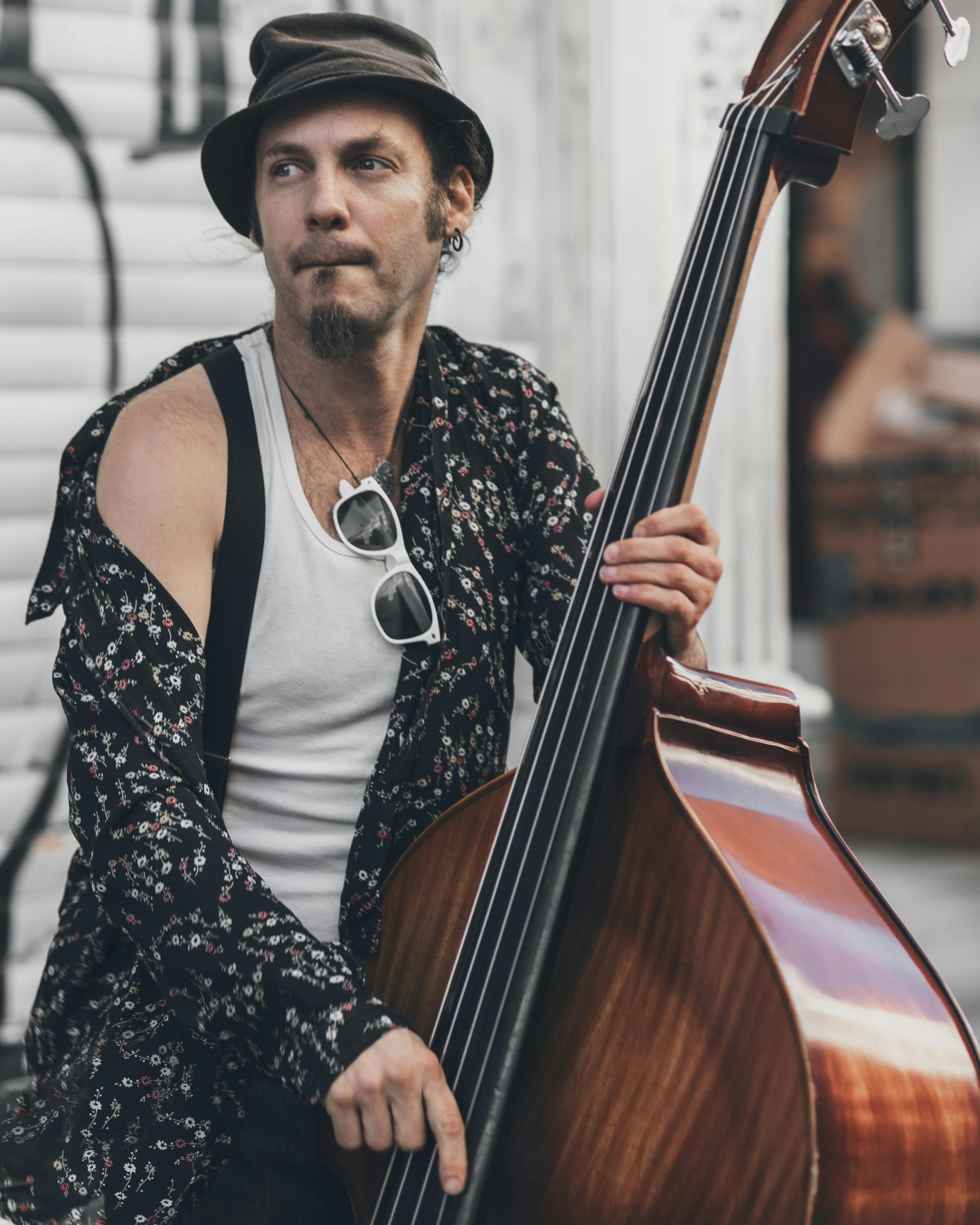 Person Wearing Long-sleeved Shirt Sitting With Double Bass