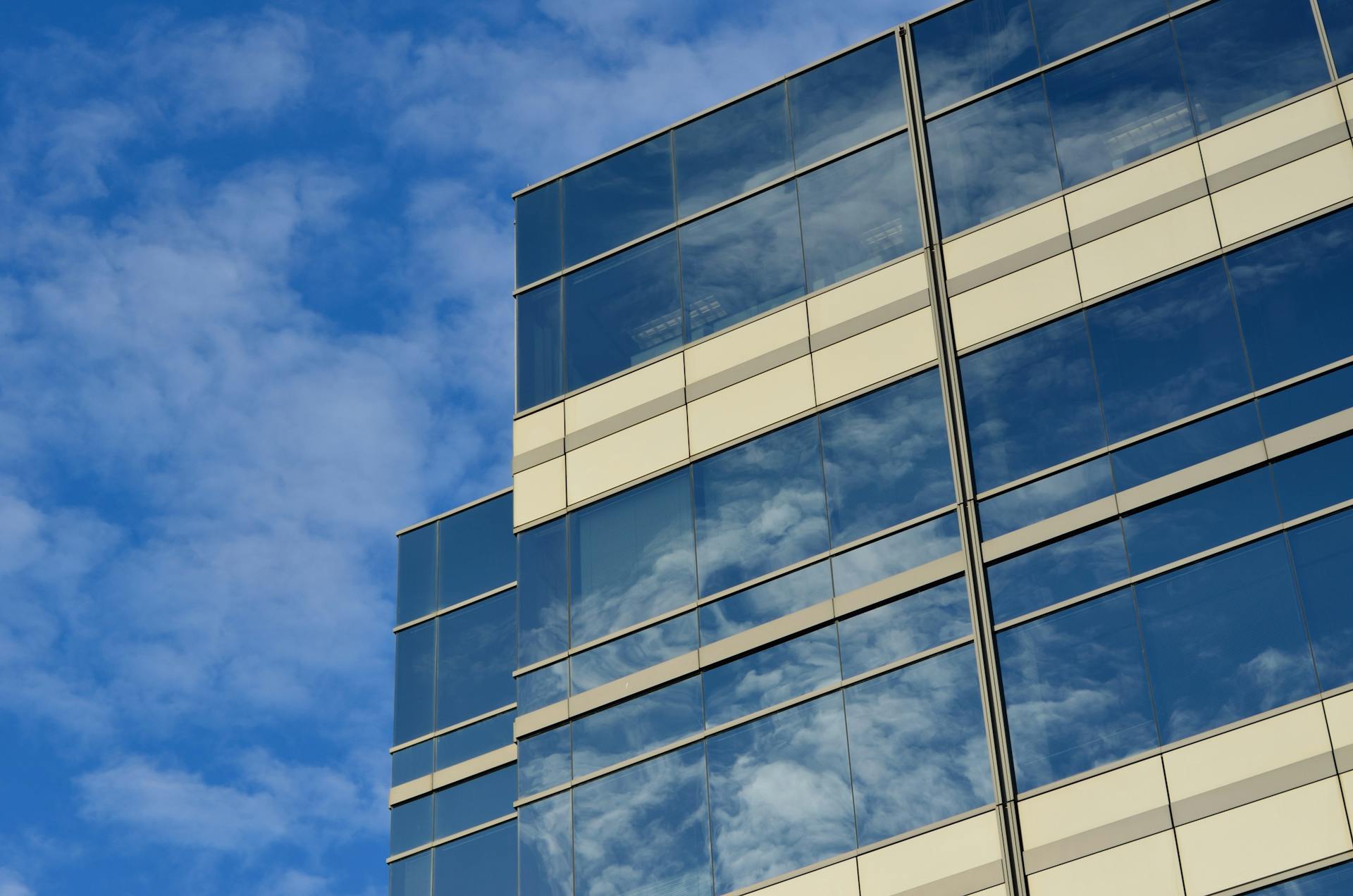A striking glass building reflecting the sky, showcasing modern architecture.