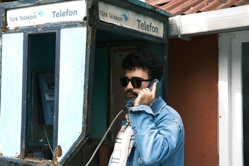 Man Pretending to Use an Old Broken Payphone 