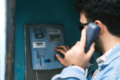 Man Using a Vintage Payphone 