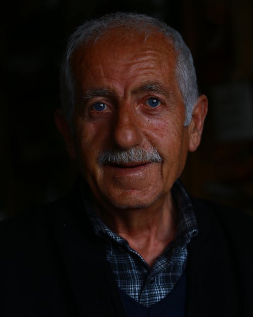 Portrait of Old Man with Moustache on Black Background