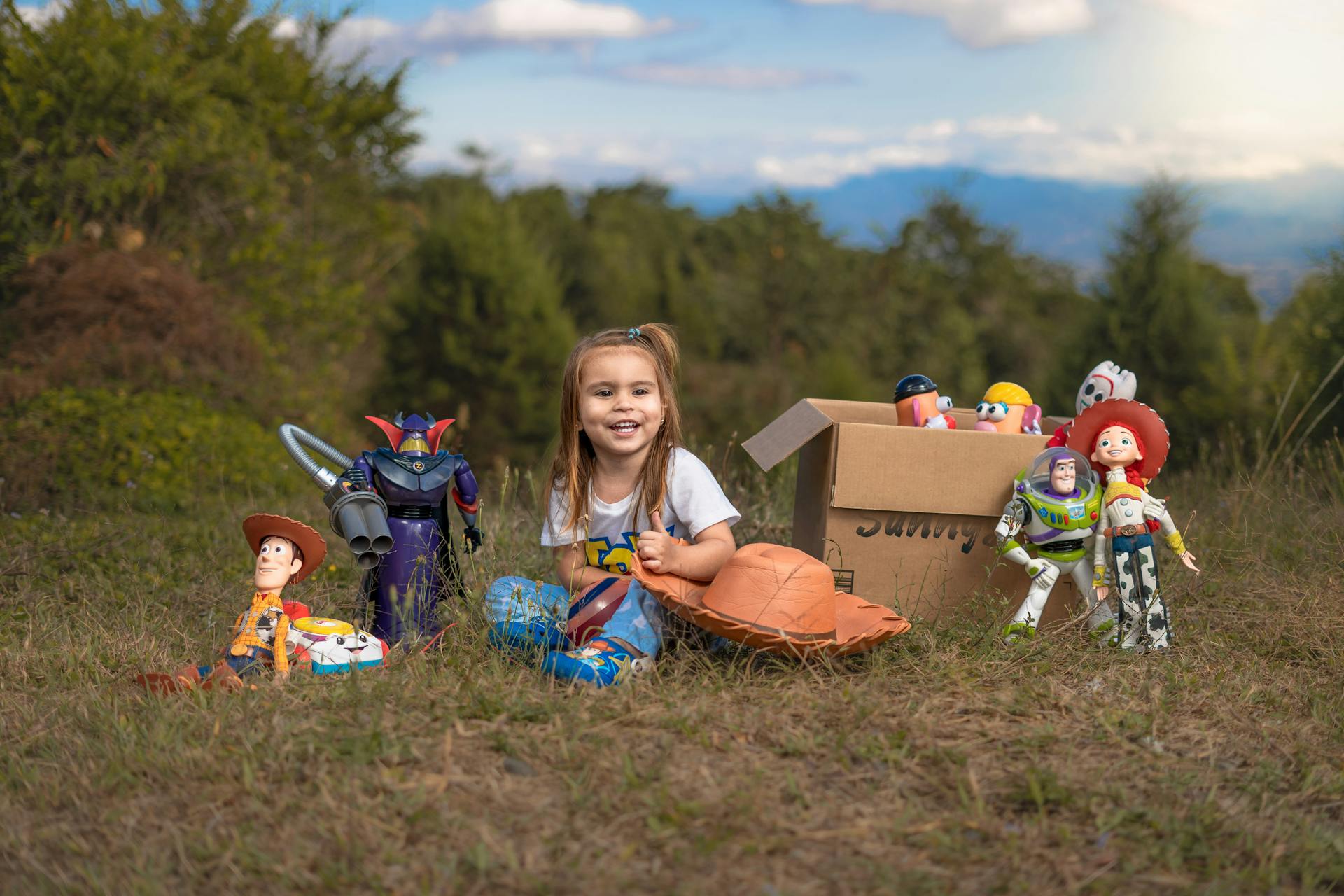 A cheerful girl plays with Toy Story characters on grassy terrain in San Juanillo, Costa Rica.