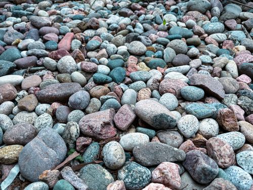 Free A variety of colorful pebbles and stones on a natural beach setting. Stock Photo