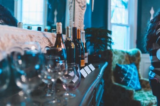 A stylish arrangement of wine bottles and glasses on an indoor table, perfect for a luxurious setting.