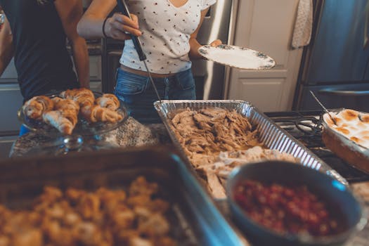 Warm indoor scene of a Thanksgiving dinner buffet featuring turkey, croissants, and side dishes.