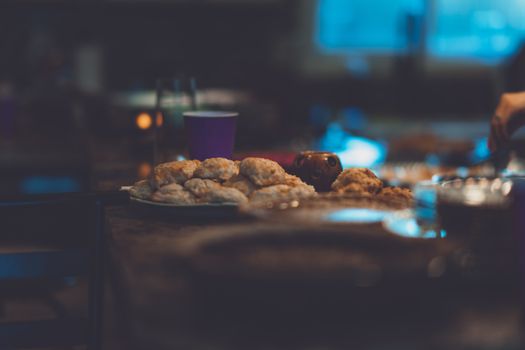 Warm, inviting dinner scene with freshly baked bread rolls on a dimly lit table.