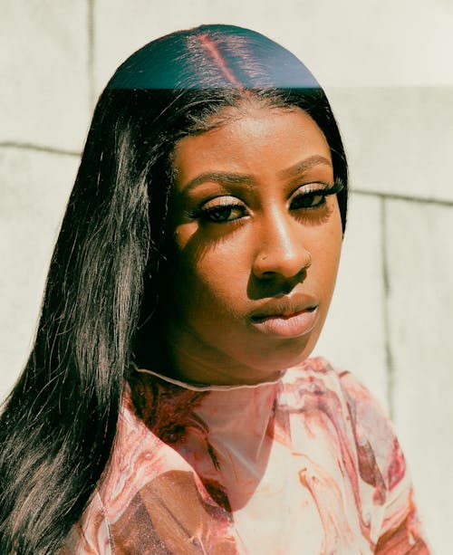 A woman with long black hair and a pink shirt