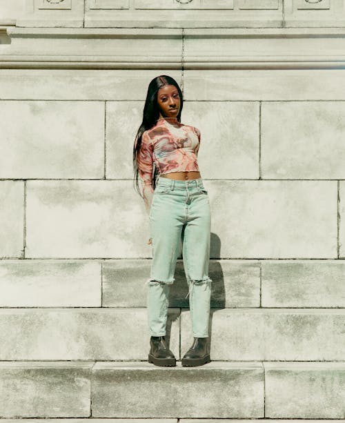 A woman standing on a set of steps with her arms crossed