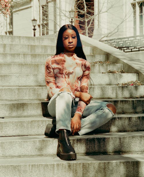 A woman sitting on some steps with her hair in a bun