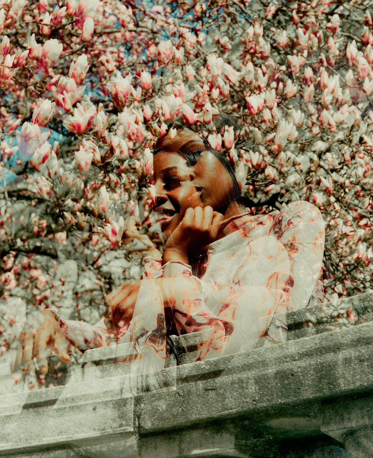 A woman is sitting on a bench in front of a tree · Free Stock Photo