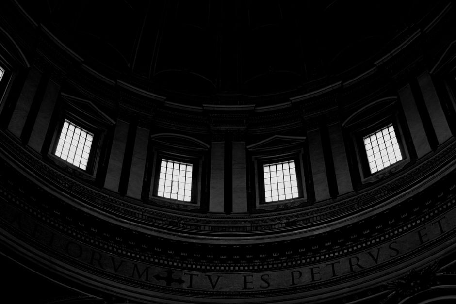 Intricate black and white interior of a dome with large windows and classic architecture.