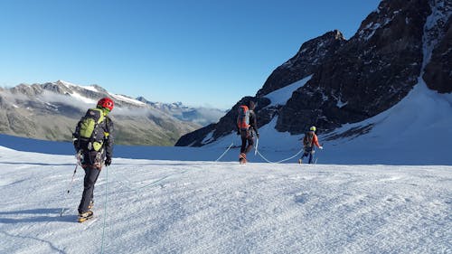 Uomo Che Cammina Sulla Montagna Coperta Di Neve