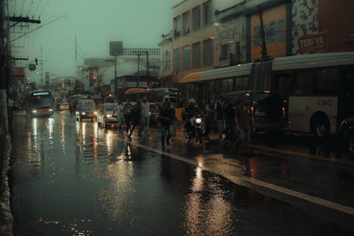 People Walking on Roadside in City during Rainfall