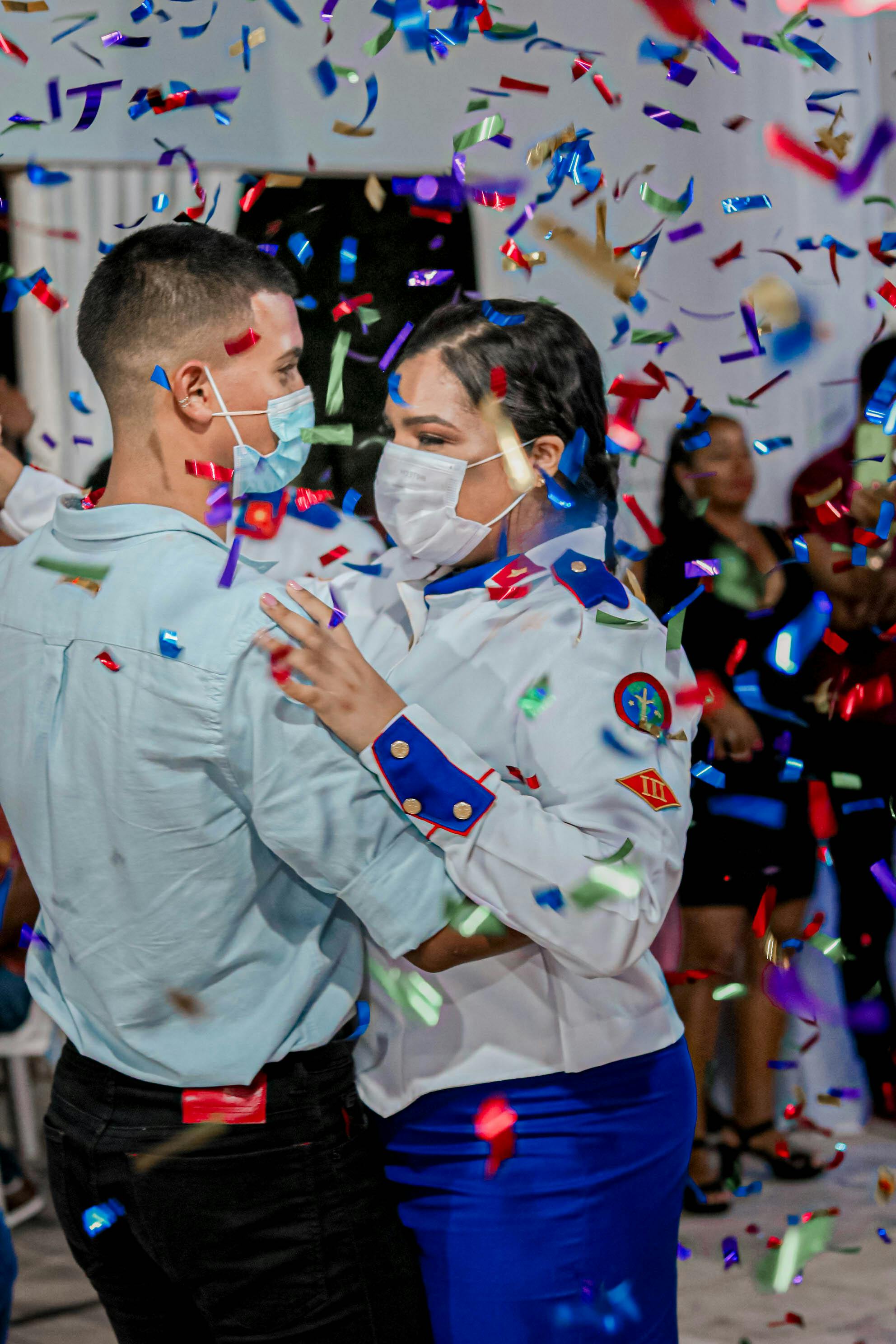 couple in uniforms dancing with confetti falling on them