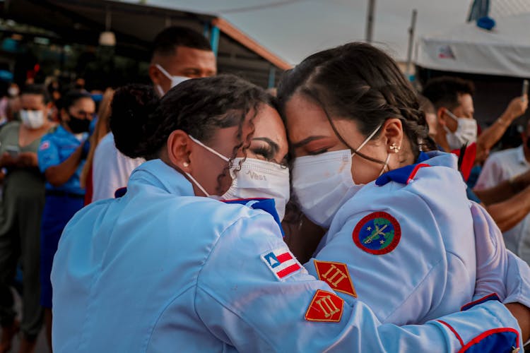 Women In Uniforms Embracing In Celebration 