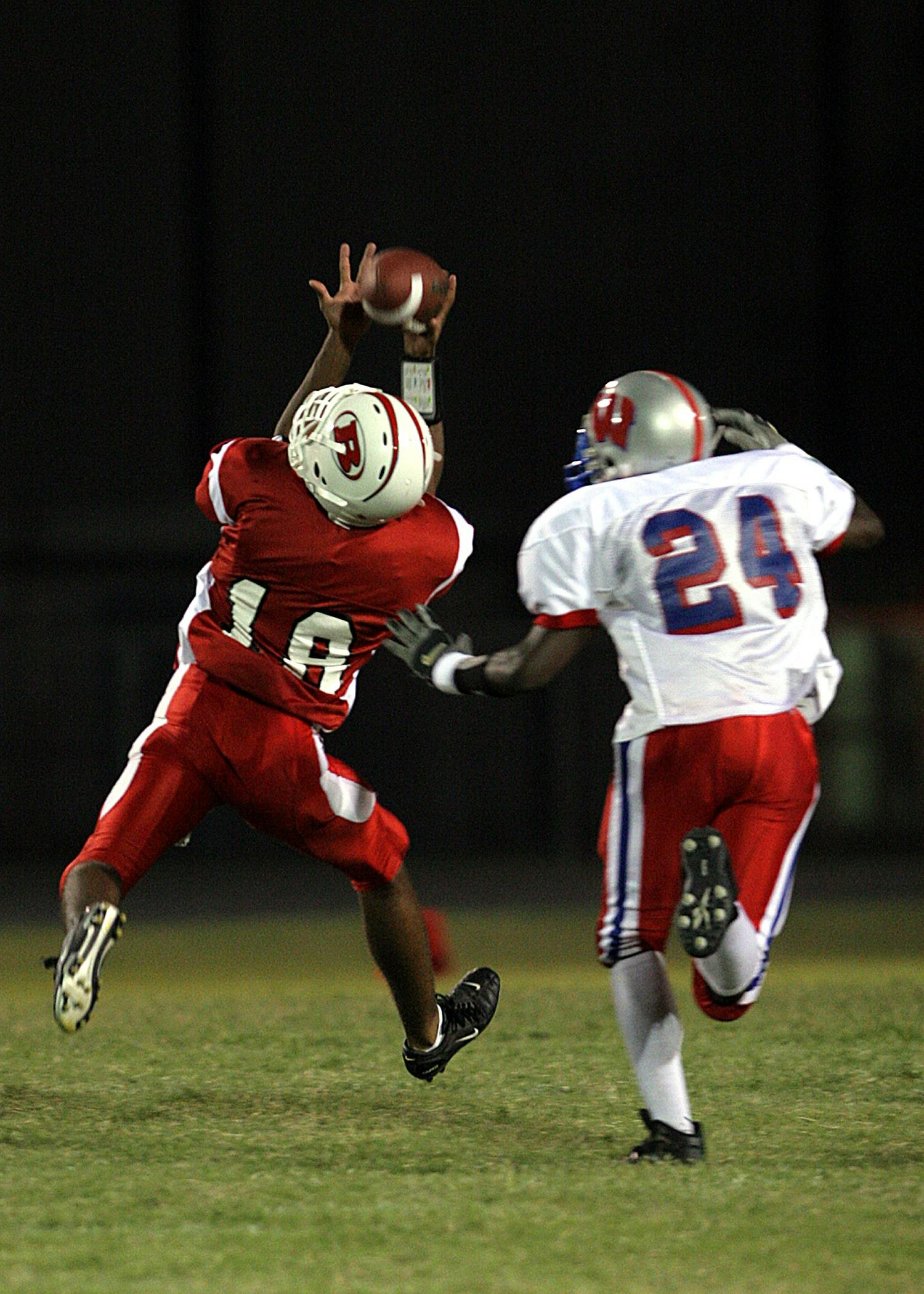 2 football player running after the ball in shallow focus photography