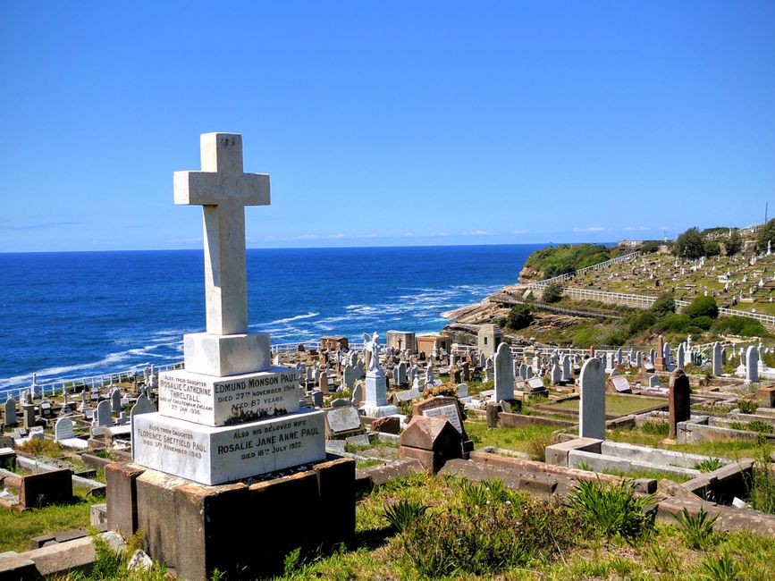 Crosses and gravestones in a seaside cemetery with ocean view at Bondi Beach, Australia.