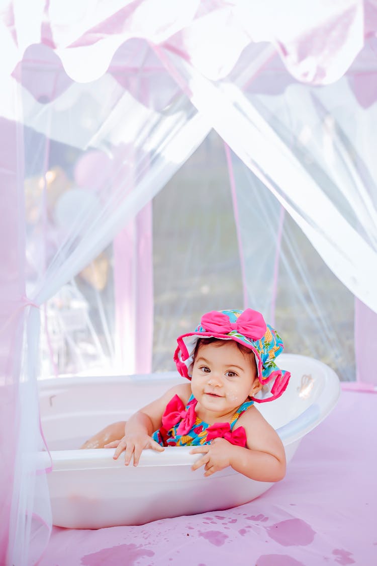 Photo Of A Cheerful Baby Playing In A Bathtub