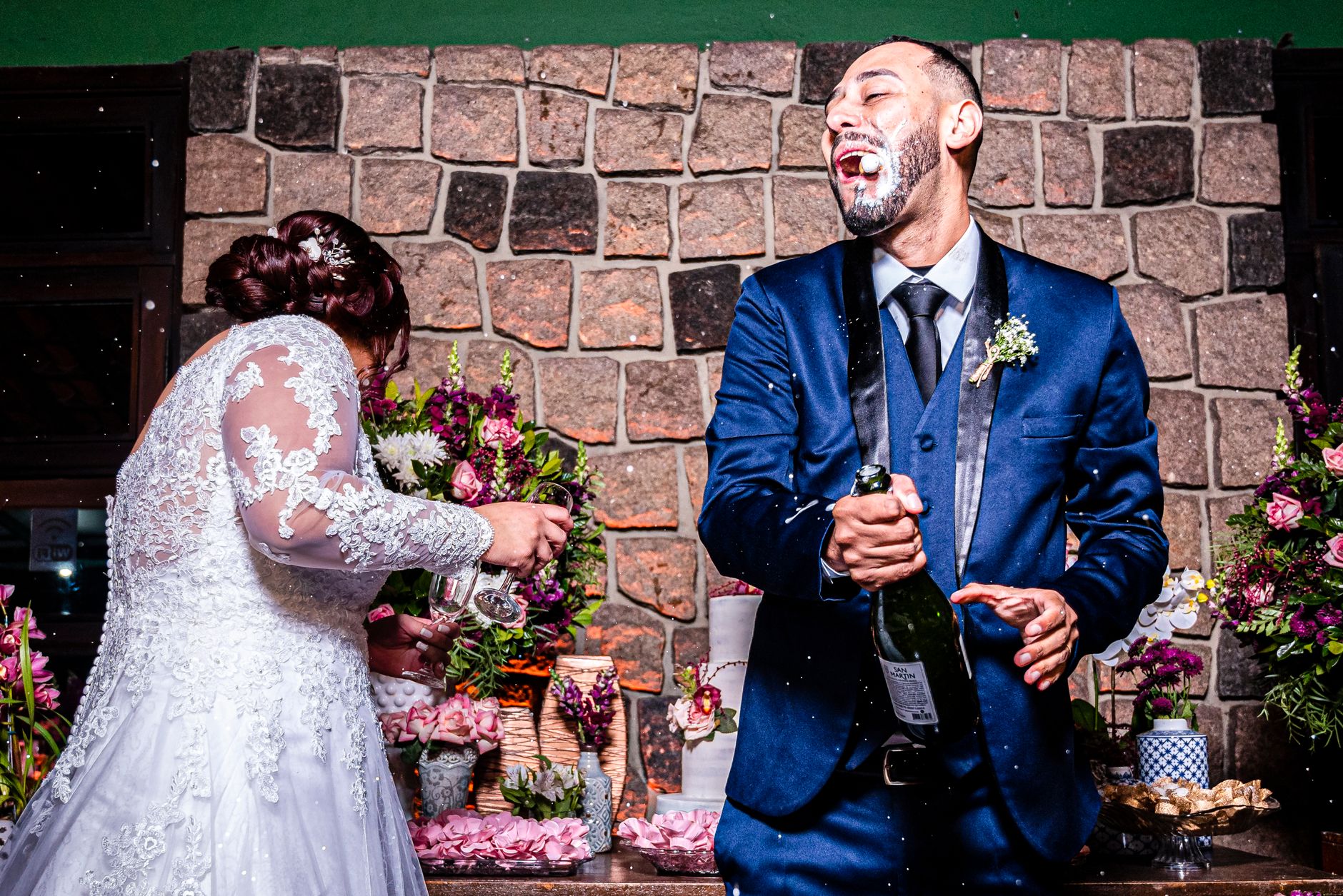 Bride and groom joyfully popping champagne at their wedding, full of laughter and celebration.