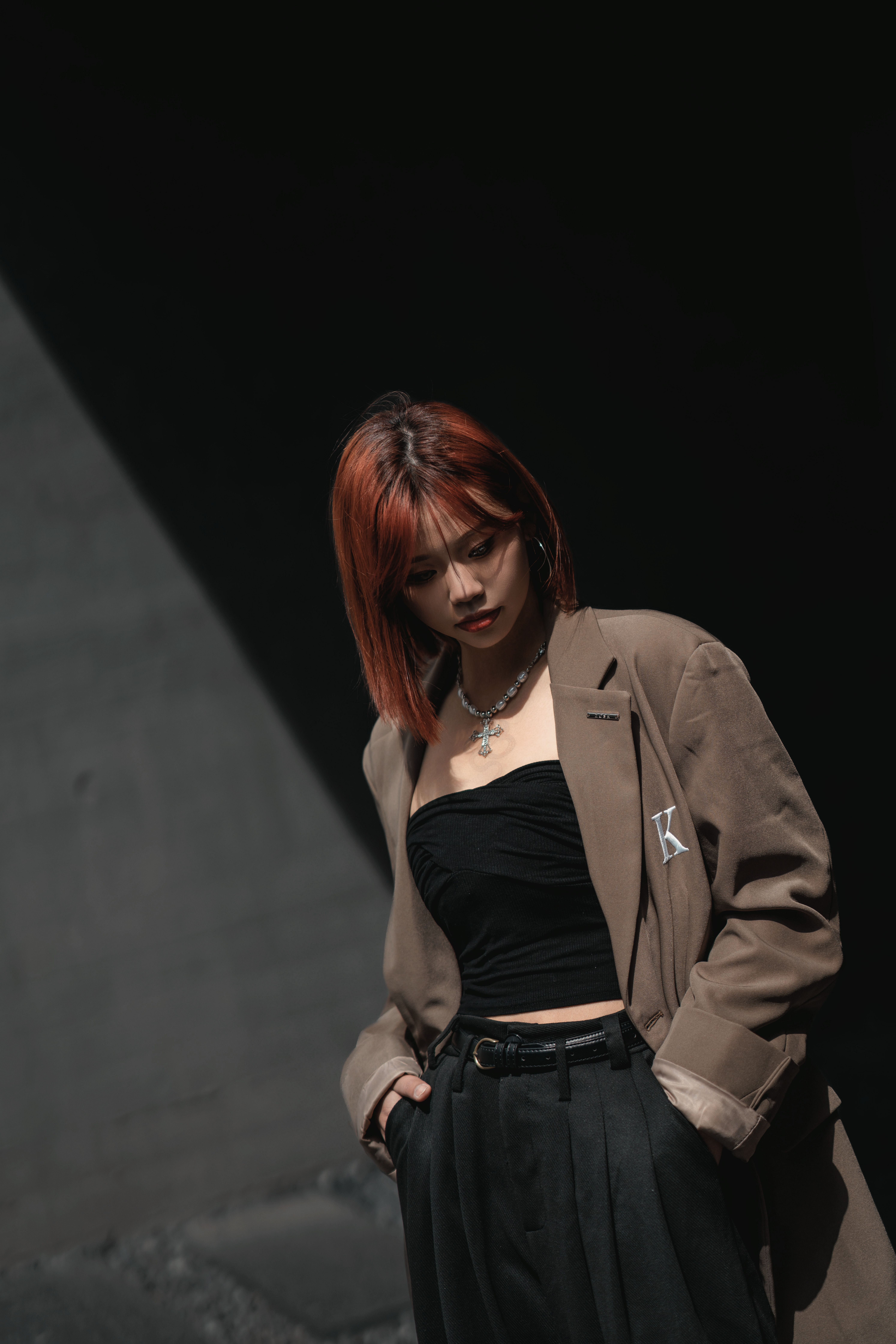 A fashionable woman poses stylishly in an urban setting, showcasing modern fashion.