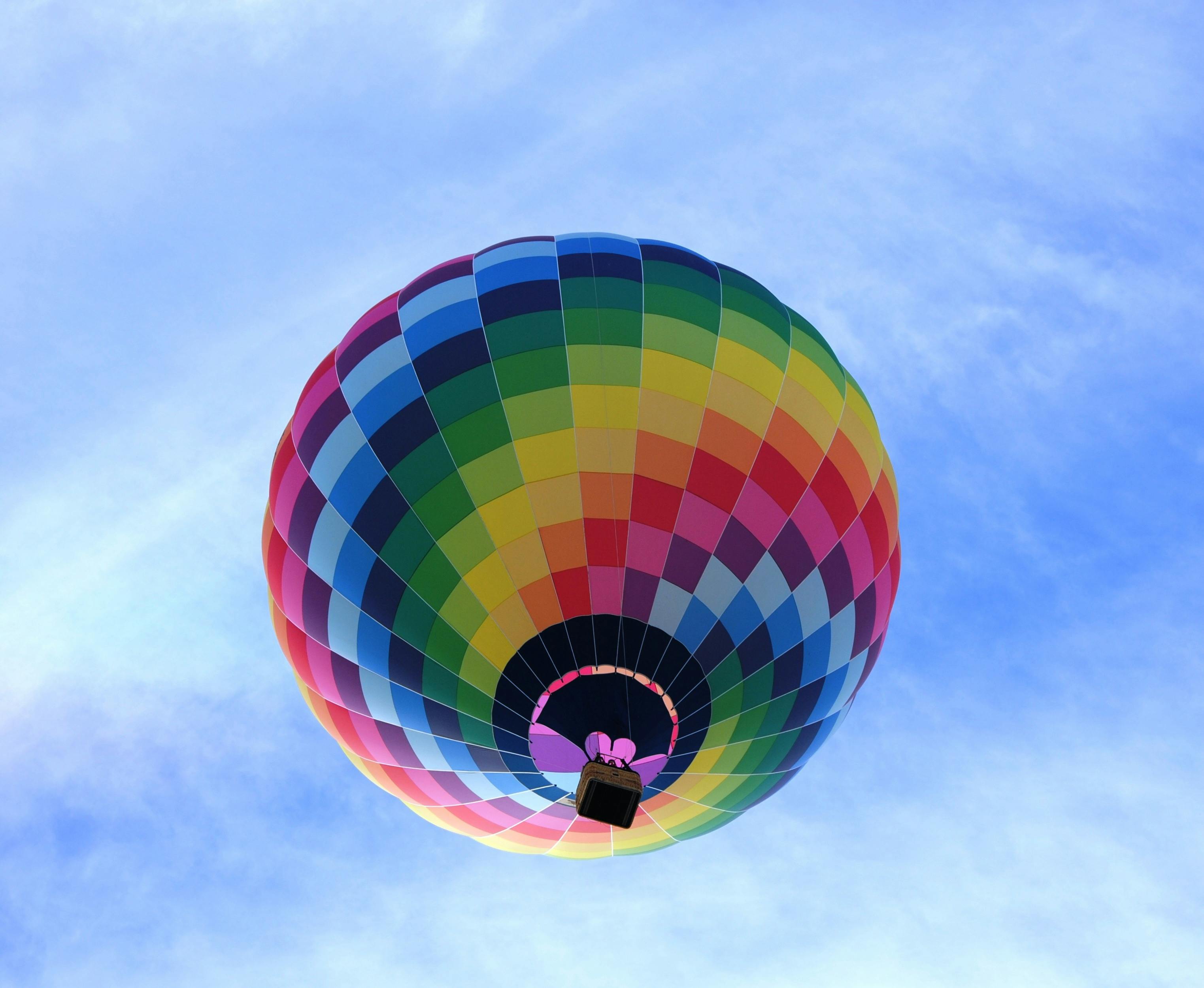 hot air balloon flying under blue sky during daytime