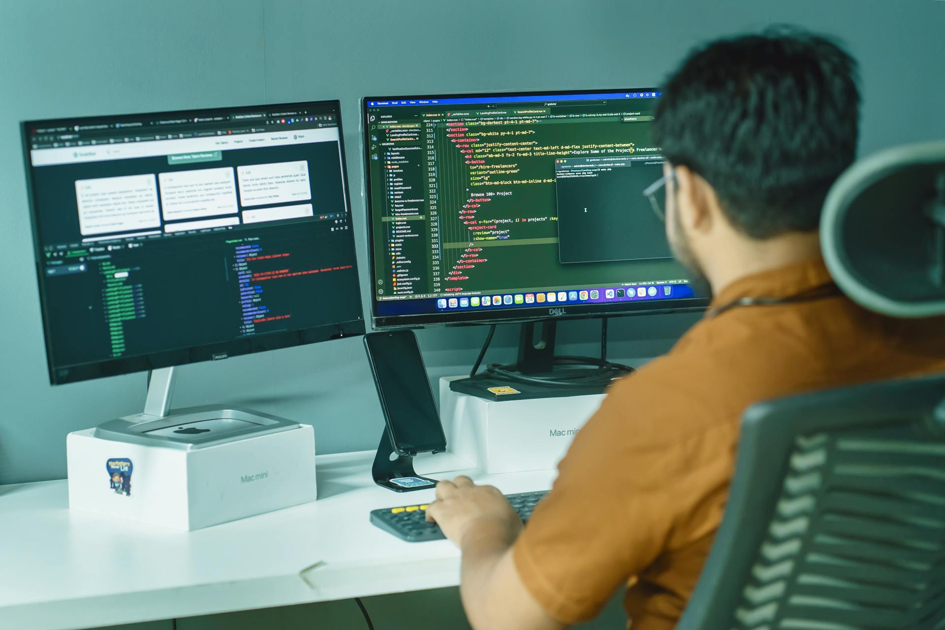 A software developer engaged in coding on dual monitors in a modern office setting.