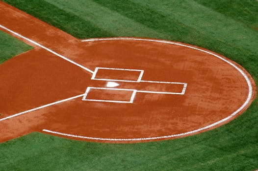 A top-down view of a baseball field's home plate area on a sunny day.