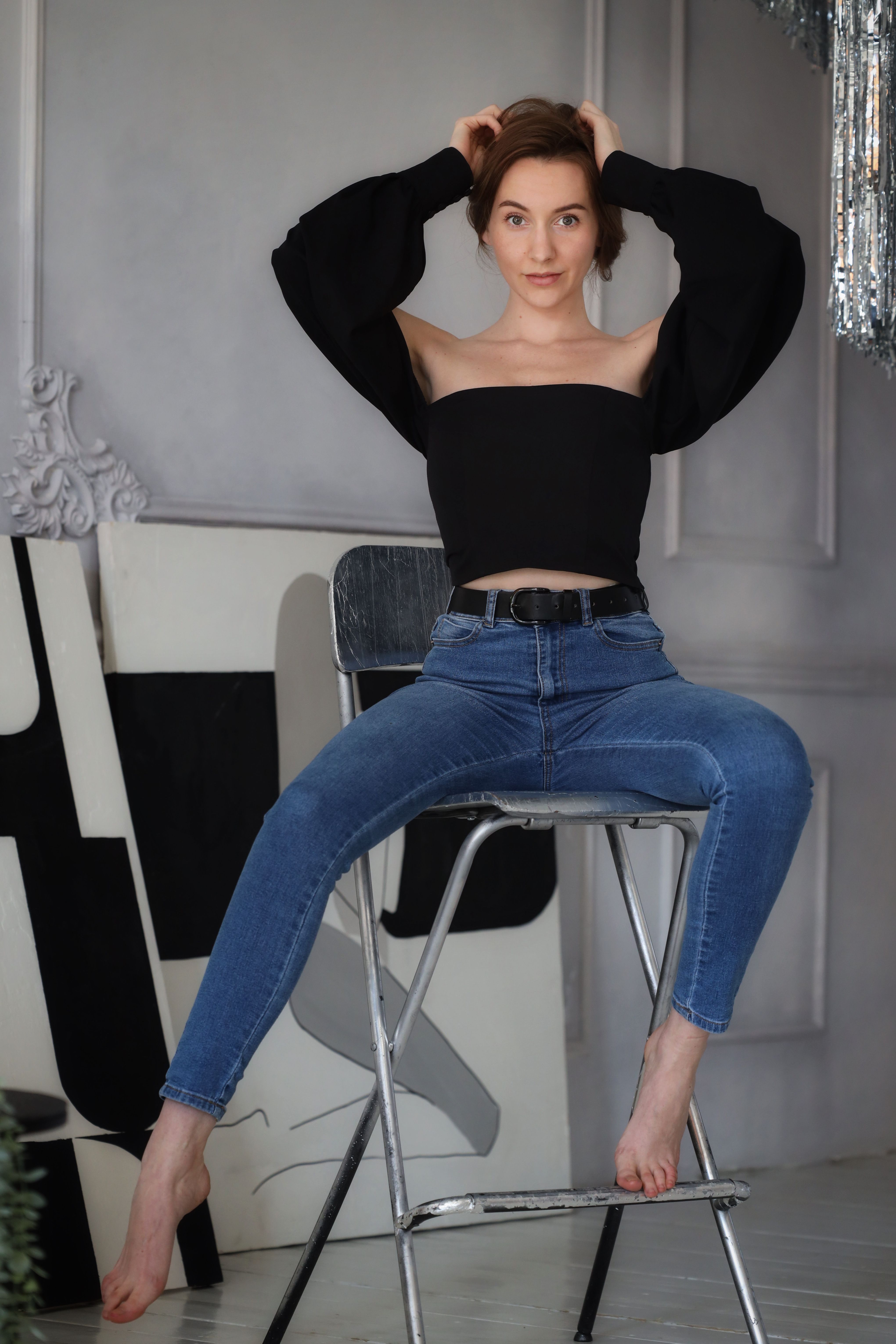 Woman Posing on a Barstool with Her Hands on Her Head · Free Stock Photo